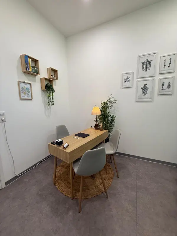 Décoration du cabinet d'ostéopathie de Kyllian Bessette à Auneau : 
            un bureau chaleureux agrémenté de plantes, d'une lampe, de cadres et d'étagères